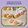 A person is shaking the Sprinkle Pop product over scones to add a touch of sophistication.