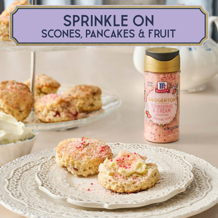 A bottle of McCormick Sprinkle On is displayed next to scones, pancakes, and fruit, suggesting its use as a topping.