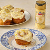 A plate of frosted lemon rolls sprinkled with McCormick Lemon Zest sits next to a bottle of the same McCormick product.