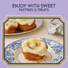 A close-up of sweet pastries with white icing and orange zest, suggesting a delightful treat.