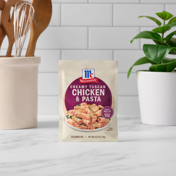 A packet of McCormick Creamy Tuscan Chicken &amp; Pasta mix stands on a kitchen counter.