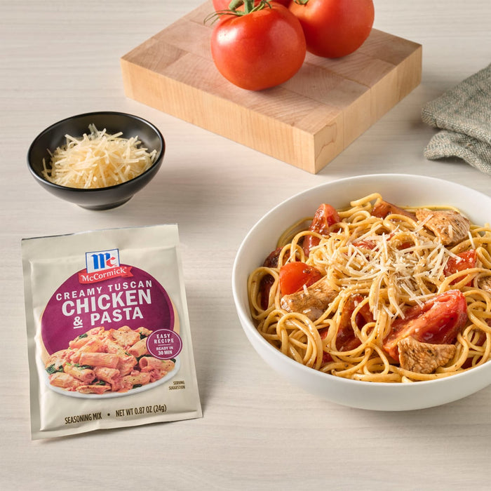 A bowl of spaghetti with McCormick Chicken &amp; Pasta seasoning, tomatoes, and parmesan cheese is displayed next to the seasoning packet, fresh tomatoes, and a bowl of parmesan.