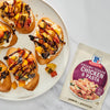 A plate of bruschetta topped with colorful vegetables and a McCormick Creamy Tuscan Chicken &amp; Pasta seasoning packet are displayed.