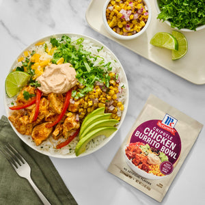 A vibrant McCormick Chicken Burrito Bowl is displayed with fresh ingredients like rice, corn, avocado, and cilantro, alongside a packet of McCormick seasoning.