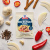 A packet of McCormick BBQ Burger Bowl seasoning mix is surrounded by fresh ingredients like garlic, onions, and peppers.