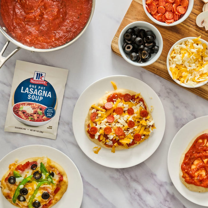 A variety of mini pizzas are displayed with toppings and a package of RAGÚ Lasagna Fillers.