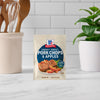 A packet of McCormick Sweet and Savory Pork Chops and Apples seasoning mix sits on a kitchen counter.