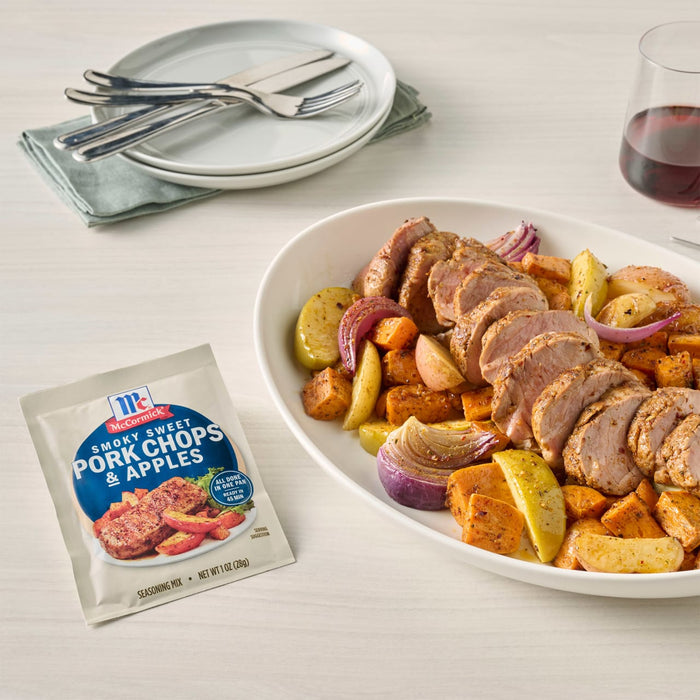 A prepared pork tenderloin with sweet potatoes and apples dish, alongside a package of McCormick Pork Tenderloin Seasoning &amp; Apples.
