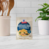 A packet of McCormick Ham and Cheese Chicken &amp; Rice Casserole mix stands on a countertop.