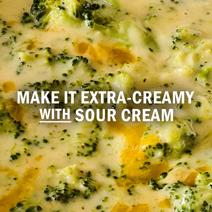 A close-up of creamy broccoli soup with the text Make it extra-creamy with sour cream.