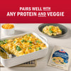 A casserole dish filled with cheesy chicken and broccoli, next to a package of Golden Chicken Crunchies, illustrating that it pairs well with any protein and veggie.