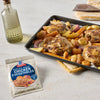 A sheet pan of roasted chicken and vegetables with a McCormick Chicken &amp; Vegetables seasoning packet.