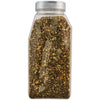 A clear plastic shaker bottle filled with a dark green and yellow spice blend.