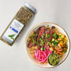 A jar of McCormick Culinary Jalapeño Ranch Seasoning is displayed next to a bowl of steak, rice, pickled onions, and vegetables seasoned with the product.