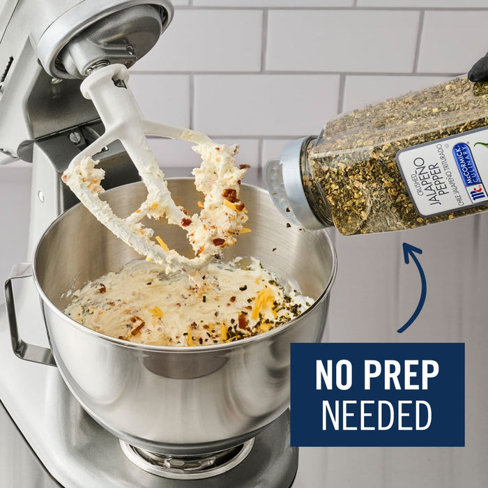 A stand mixer is shown with a paddle attachment mixing ingredients, while a bottle of McCormick Perfect Pinch Salad Supreme Seasoning is being poured into the bowl, highlighting the convenience of no prep needed.