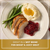 A plated holiday meal featuring sliced turkey seasoned with Mccormick Turkey Dry Brine Rub, 12.2 Oz alongside mashed potatoes with gravy, green beans, and cranberry sauce.