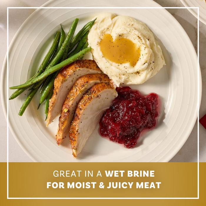 A plated holiday meal featuring sliced turkey seasoned with Mccormick Turkey Dry Brine Rub, 12.2 Oz alongside mashed potatoes with gravy, green beans, and cranberry sauce.