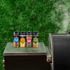 A collection of Traeger spice rubs sits on a grill, suggesting outdoor cooking and flavor enhancement.