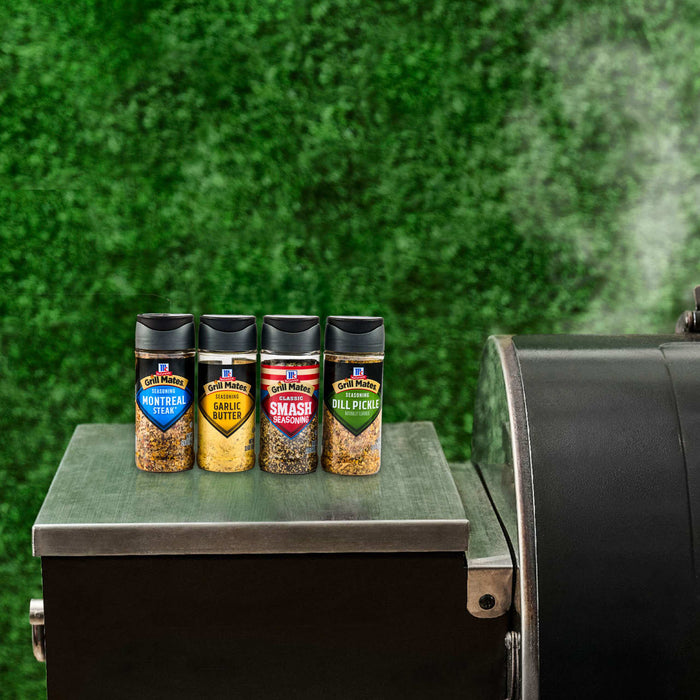 A collection of Traeger spice rubs sits on a grill, suggesting outdoor cooking and flavor enhancement.