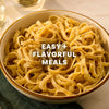 A close-up of a bowl of fettuccine pasta seasoned with Mccormick Garlic And Olive Oil Seasoning Blend, 5.25 Oz, with the words Easy + Flavorful Meals overlaid on the image.