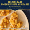 Several golden, flaky treacle tart mini tarts are shown on a white plate, finished with a generous sprinkle of Mccormick Harry Potter Treacle Tart Finishing Sugar, 3.43 Oz, in a promotional recipe image.