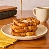 A delicious stack of French toast is topped with a pat of butter, drizzled with syrup, and sprinkled with Mccormick Harry Potter Treacle Tart Finishing Sugar, 3.43 Oz for a magical breakfast.