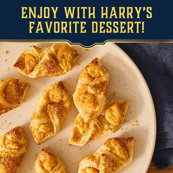 A hand dips a strawberry into a bowl of creamy dip sprinkled with Mccormick Harry Potter Licorice Wand Finishing Sugar, 3.39 Oz, to create a magical treat.