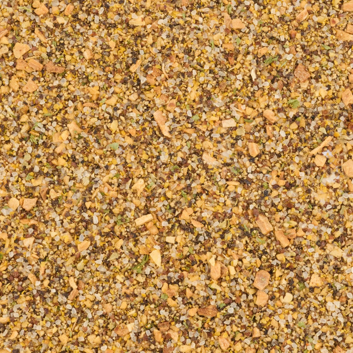 A close-up, top-down view reveals the coarse texture of Mccormick Grill Mates Peppercorn And Worcestershire Seasoning Cracked 2.75 Oz, showing a mix of cracked peppercorns, salt crystals, and other dried spices.