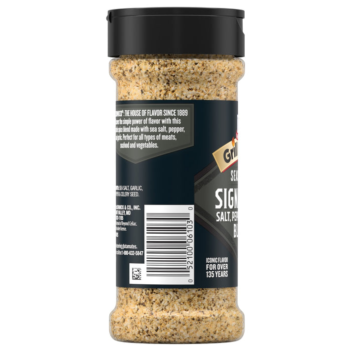 The back of a clear shaker bottle of Grill Mates Signature Blend Seasoning, 6.53 Oz Bottle, shows the seasoning mix inside and displays the ingredients list and barcode on the black label.