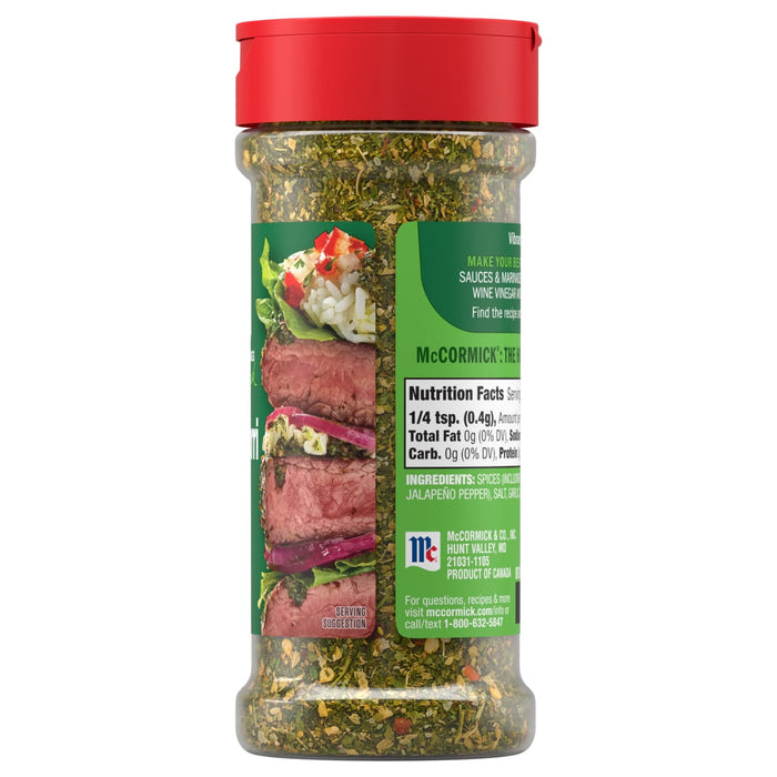 A clear bottle of Mccormick, 2.47 Oz seasoning with a red cap displays its green herb and spice blend, with the label showing nutrition facts and a serving suggestion of seasoned steak.
