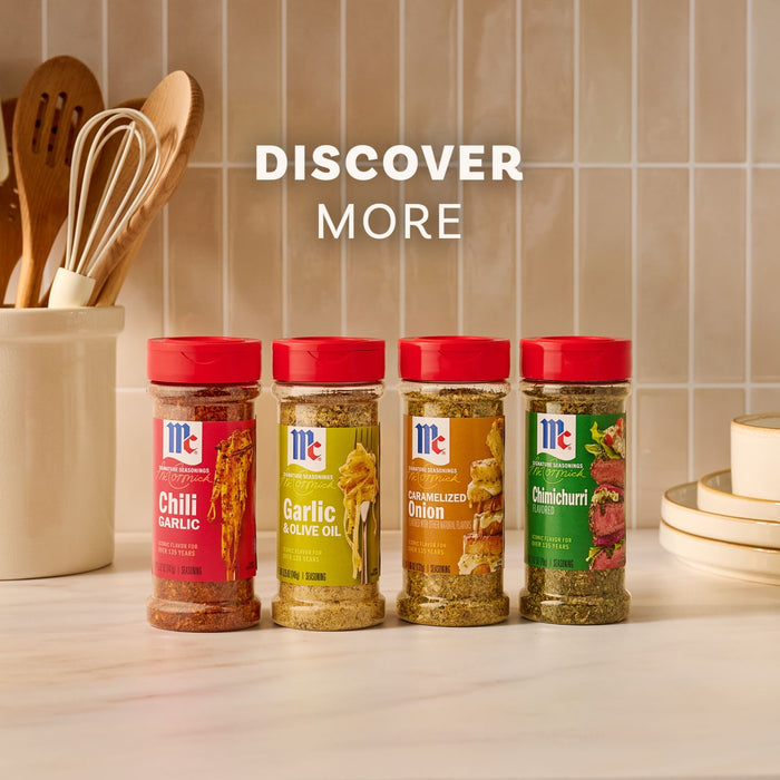 Four McCormick Signature Seasonings, including Chili Garlic, Garlic &amp; Olive Oil, Caramelized Onion, and a bottle of Mccormick Chimichurri Flavored Seasoning, 2.47 Oz, are lined up on a kitchen counter under the words DISCOVER MORE.