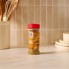 A bottle of Mccormick Caramelized Onion Seasoning, 4.66 Oz, is displayed on a kitchen counter in front of a tiled backsplash, suggesting its use in home cooking.