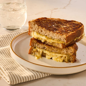 A perfectly toasted grilled cheese sandwich, cut and stacked to show the gooey melted cheese, presents a delicious recipe idea using Mccormick Caramelized Onion Seasoning, 4.66 Oz.