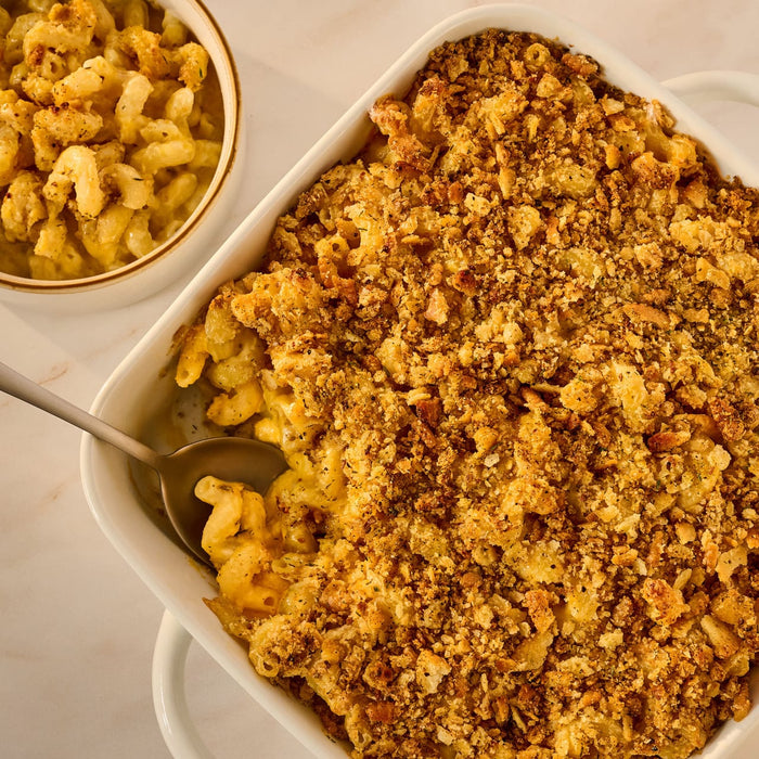 A large white casserole dish holds baked macaroni and cheese with a golden-brown breadcrumb topping made with Mccormick Caramelized Onion Seasoning, 4.66 Oz.