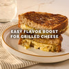 A perfectly toasted grilled cheese sandwich, cut in half and stacked, demonstrates an easy flavor boost using Mccormick Caramelized Onion Seasoning, 4.66 Oz.