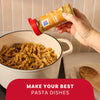 A hand sprinkles Mccormick Caramelized Onion Seasoning, 4.66 Oz, over a creamy pasta and mushroom dish in a white pot, demonstrating how to make your best pasta dishes.