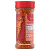 A clear bottle of Mccormick, 5.22 Oz spice blend shows the red and orange flakes inside, with a label featuring a serving suggestion of seasoned noodles.