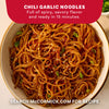 A close-up shot of a bowl of chili garlic noodles, a delicious meal idea made with Mccormick Chili Garlic Seasoning, 5.22 Oz, garnished with sesame seeds and green onions.