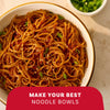 A close-up, overhead shot shows a white bowl filled with noodles tossed with sesame seeds, green onions, and Mccormick Chili Garlic Seasoning, 5.22 Oz, with a red banner at the bottom that reads, Make Your Best Noodle Bowls.