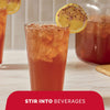 A refreshing glass of iced tea garnished with a lemon slice shows how Mccormick Blueberry And Lemon Finishing Sugar, 3.43 Oz can be stirred into beverages for added flavor.