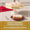 A slice of creamy cranberry topped pound cake sits on a red plate next to a fork, showcasing the decorative sprinkle of Mccormick Cranberry Finishing Sugar, 3.43 Oz on top.