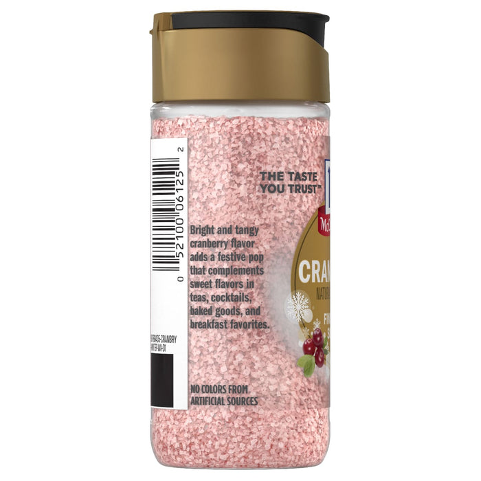 A side view of a bottle of Mccormick, 3.43 Oz cranberry flavored finishing sugar showing the pink granules and a label that describes its bright and tangy flavor profile.