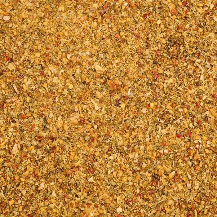 A close-up, top-down view shows the texture of the Mccormick Greek Style Seasoning, 3.88 Oz, revealing a colorful mix of dried herbs, spices, and seeds.