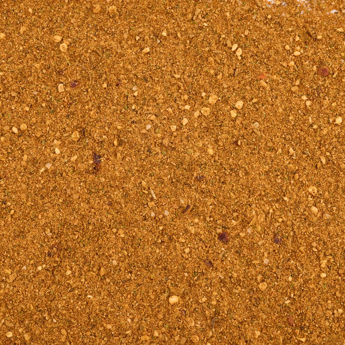 A close-up, top-down view shows the rich, orange-brown texture of Mccormick Moroccan Style Seasoning, 4.62 Oz, revealing a blend of fine and coarse spices.