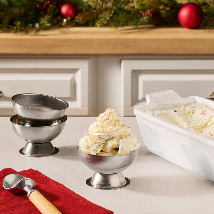 A festive dessert scene features a scoop of vanilla ice cream topped with a swirl of whipped cream and a dusting of Mccormick Sugar Cookie Finishing Sugar 3.39 Oz in a silver bowl.