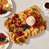 A breakfast grazing board features waffles, mini pancakes, and French toast sticks all dusted with Mccormick Sugar Cookie Finishing Sugar 3.39 Oz alongside fresh berries and whipped cream.