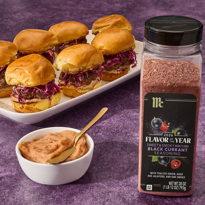 A jar of McCormick Flavor of the Year 2026 Sweet &amp; Smoky Black Currant Seasoning is displayed next to a bowl of sauce and a plate of sliders.