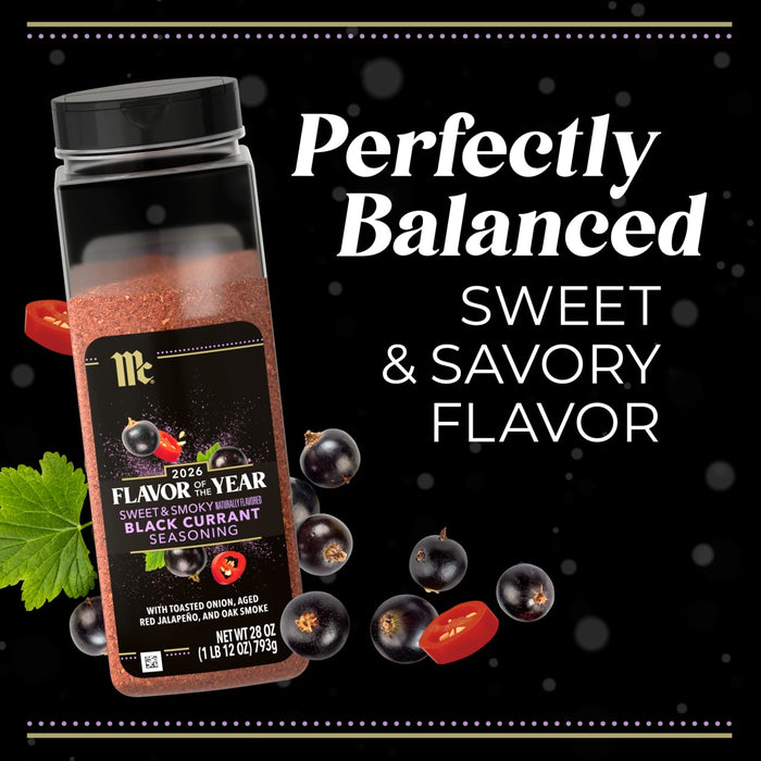 A bottle of McCormick Flavor of the Year 2026 Sweet &amp; Smoky Naturally Flavored Black Currant Seasoning is surrounded by black currants and sliced red jalapeño.