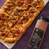 A flatbread pizza cut into squares sits next to a container of McCormick Flavor of the Year Sweet &amp; Smoky Black Currant Seasoning.