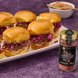 A jar of McCormick Flavor of the Year 2026 Sweet &amp; Smoky Naturally Flavored Black Currant Seasoning sits next to a platter of slider sandwiches.